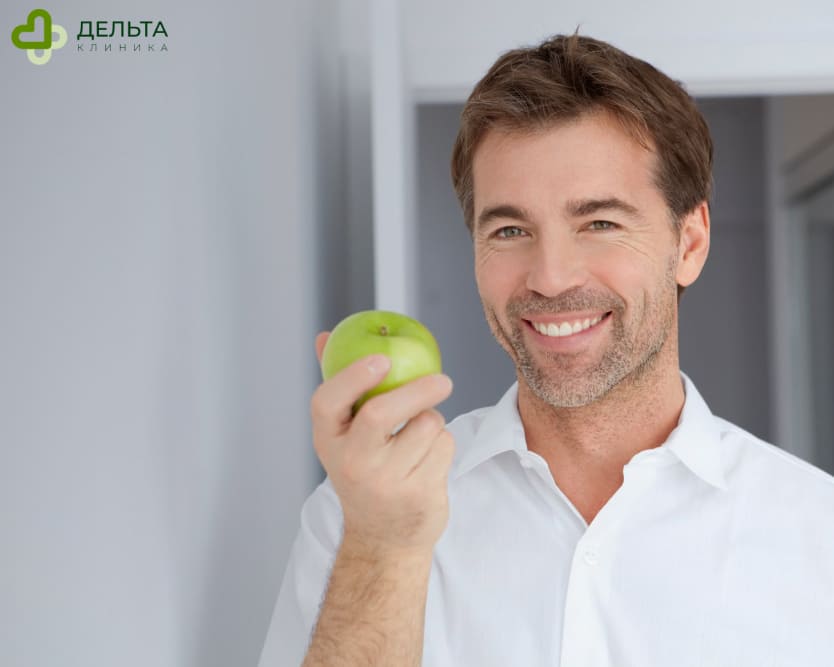 Мужчина держит в руке яблоко